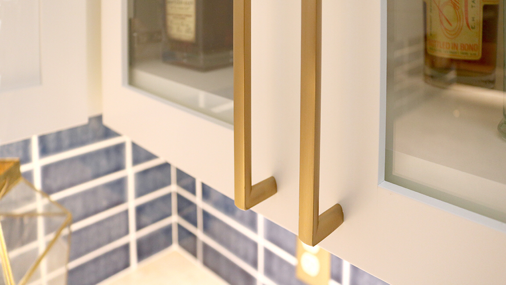 White glass-front upper cabinets with brass hardware