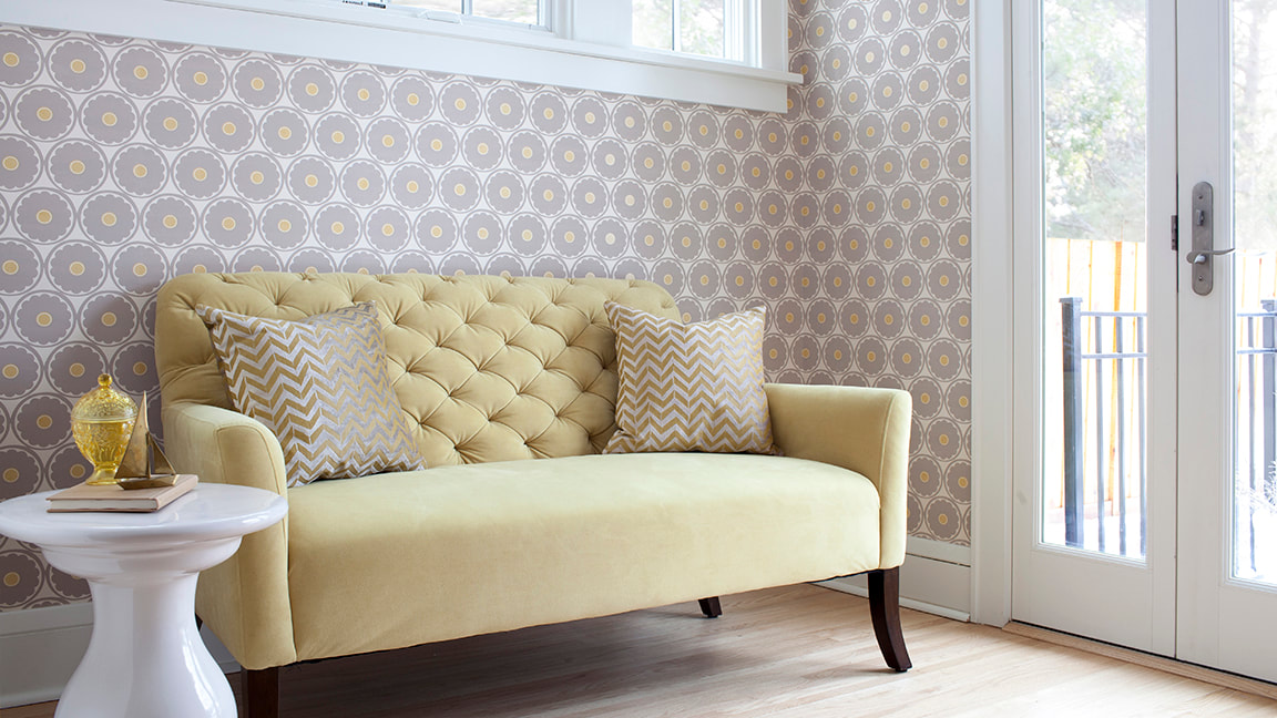 Yellow couch and patterned wallpaper
