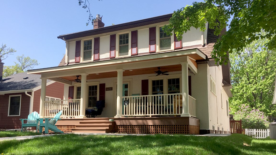 Traditional covered front porch with round columns and beadboard ceiling